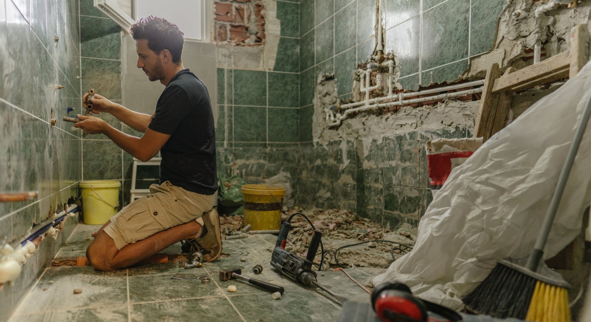 Plumber installing pipe fittings during a bathroom renovation project.